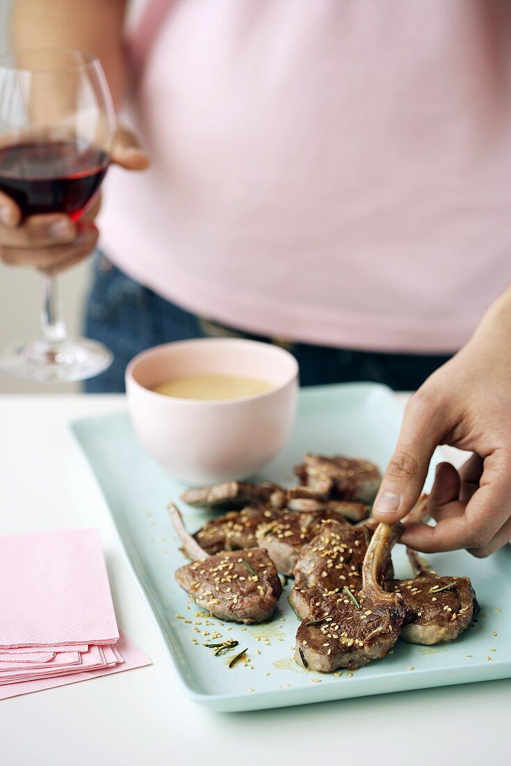 Woman picking up fried lamb chop