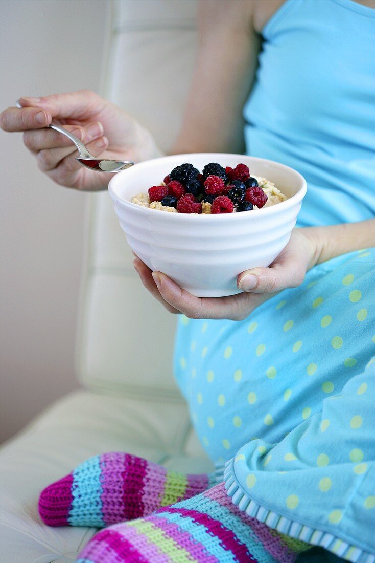 Woman eating muesli with berries