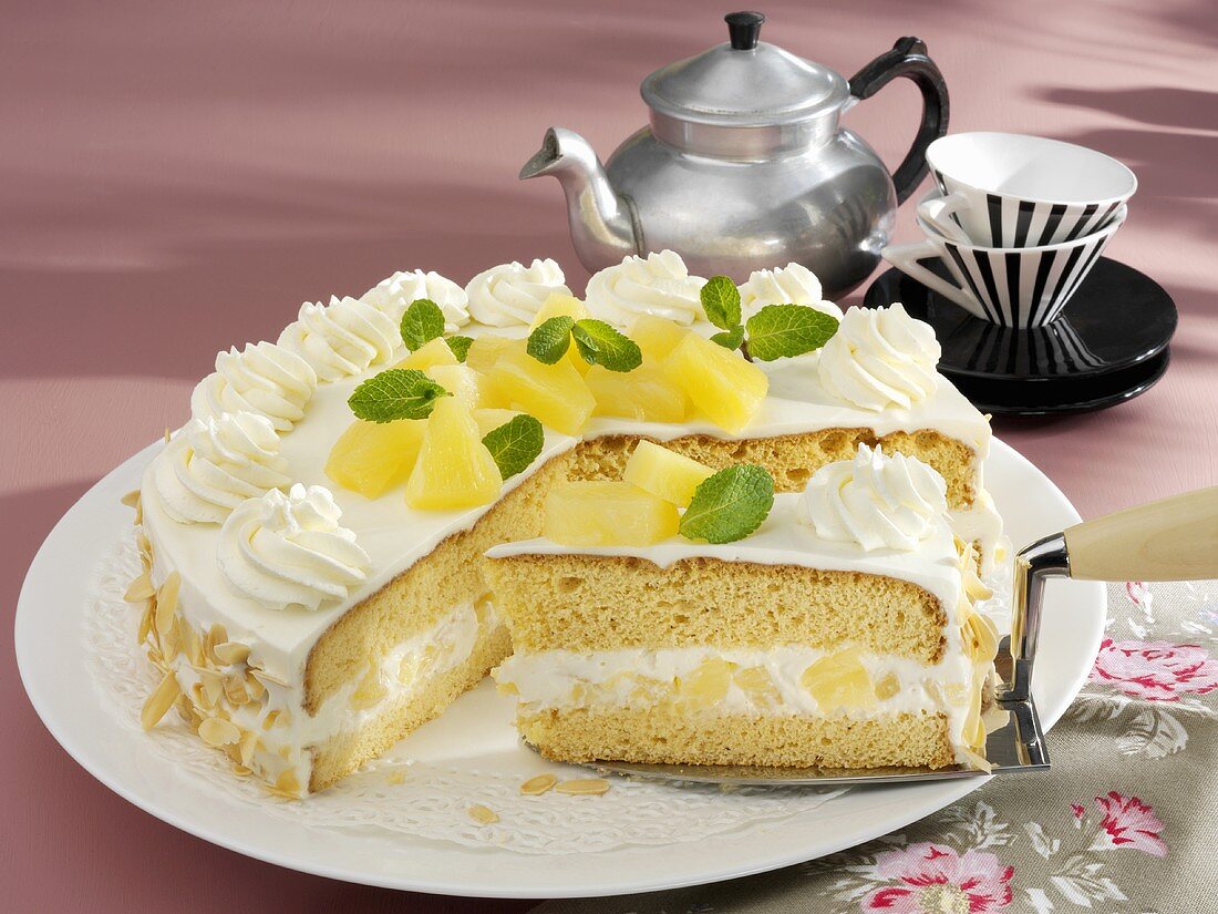 Cream cake with pineapple and cream cheese filling, a piece cut