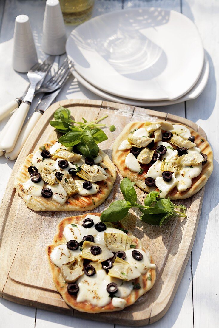 Minipizzen mit Mozzarella, Artischocken und Oliven