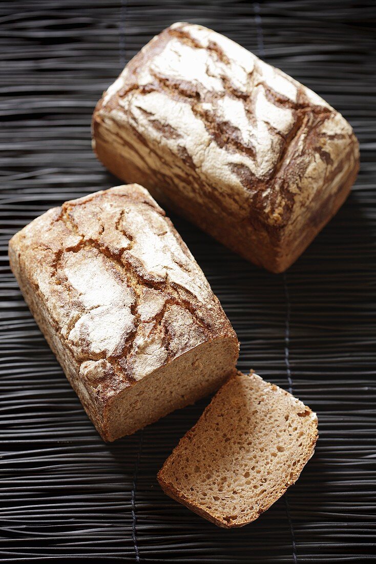 Loaves of wholemeal bread, one with a slice cut