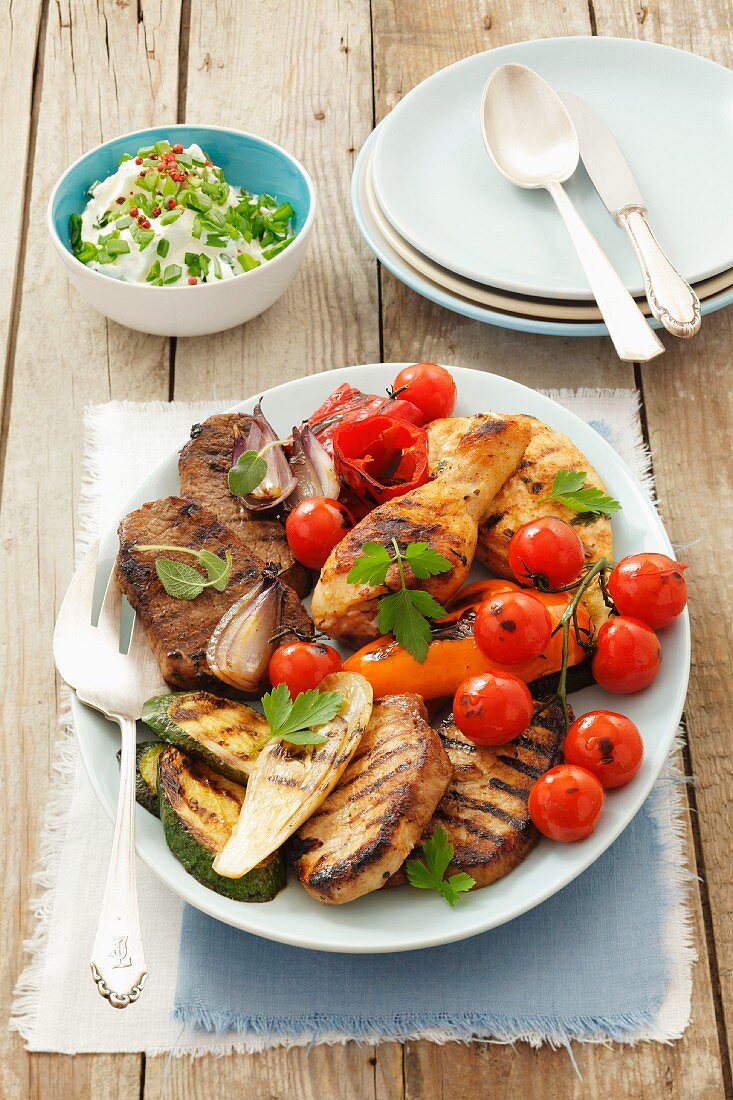 Gemischte Grillplatte mit Hähnchenkeulen, Rind- , Schweinefleisch und Gemüse