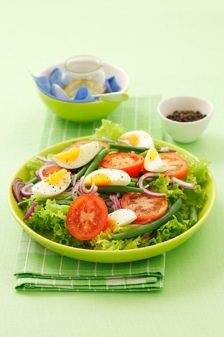Salat mit Ei, grünen Bohnen, Blattsalat, Zwiebel und Tomaten