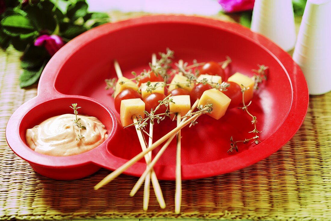 Cheese and tomatoes on cocktail sticks with dip