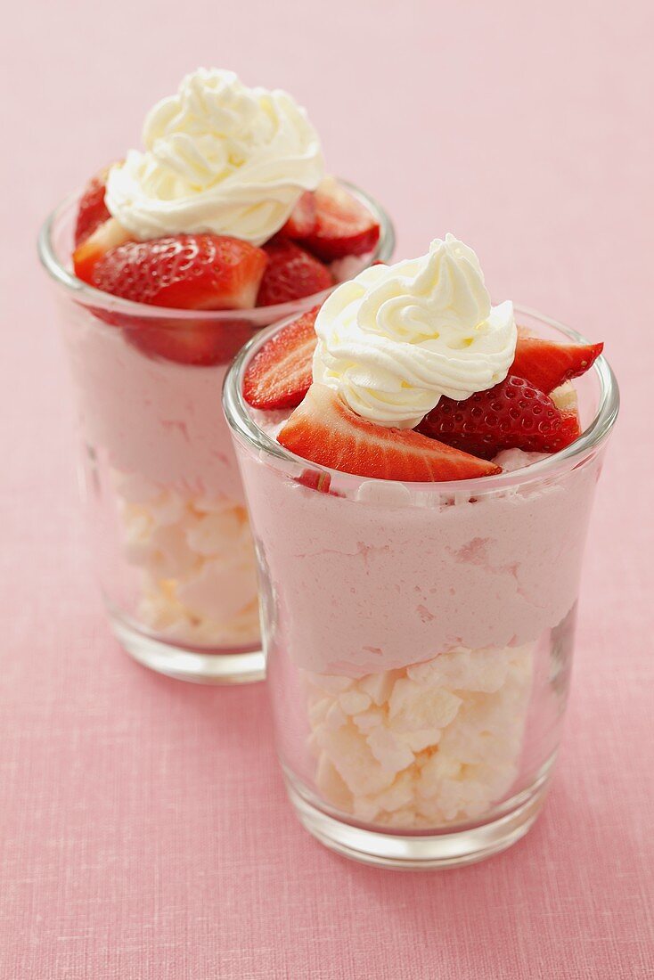 Layered dessert: meringue, strawberry mousse, fresh strawberries & cream