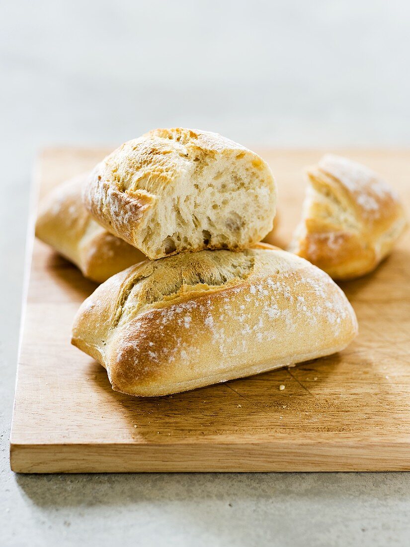 Several bread rolls on chopping board