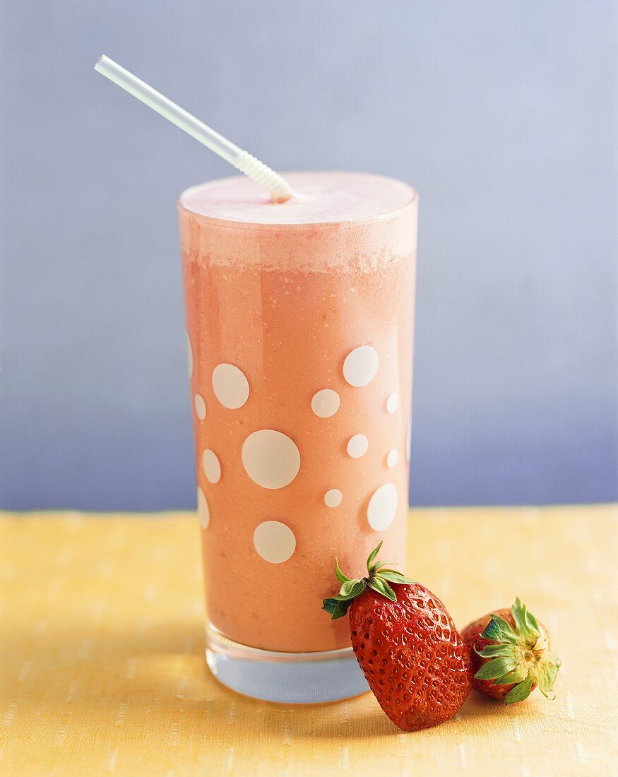 Strawberry milkshake with straw in a glass