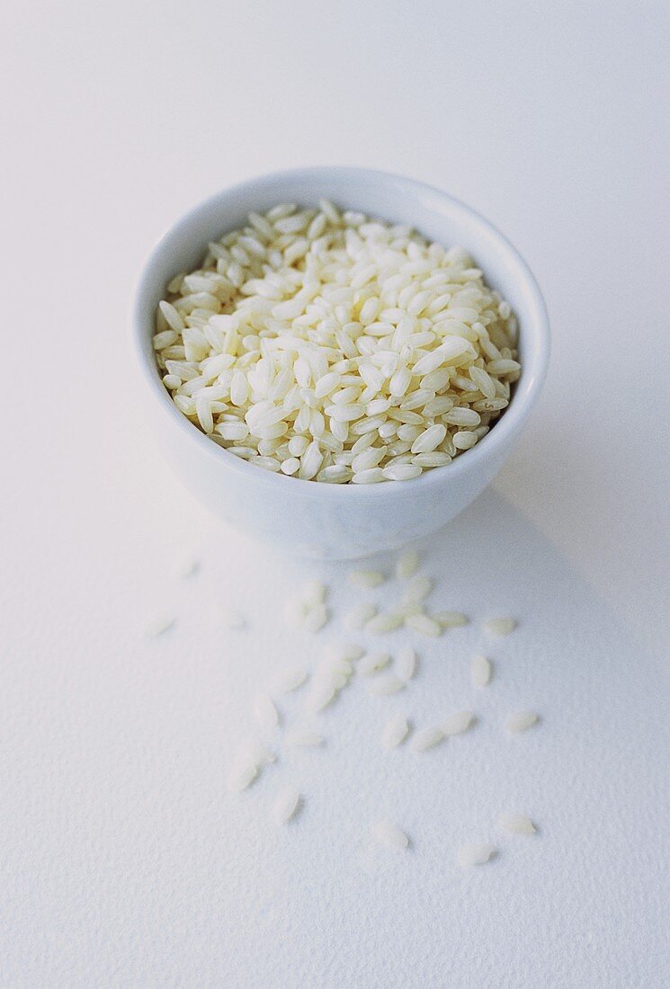 Weisser Reis in einem weissen Schälchen und davor