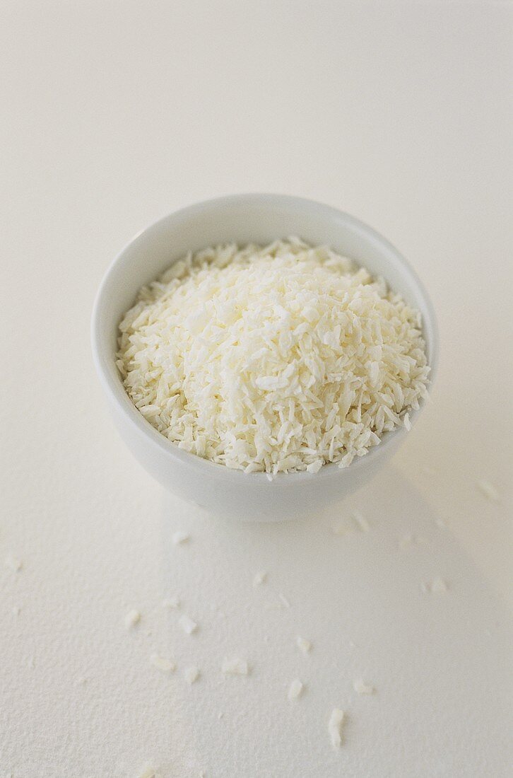 Grated coconut in and in front of a small bowl