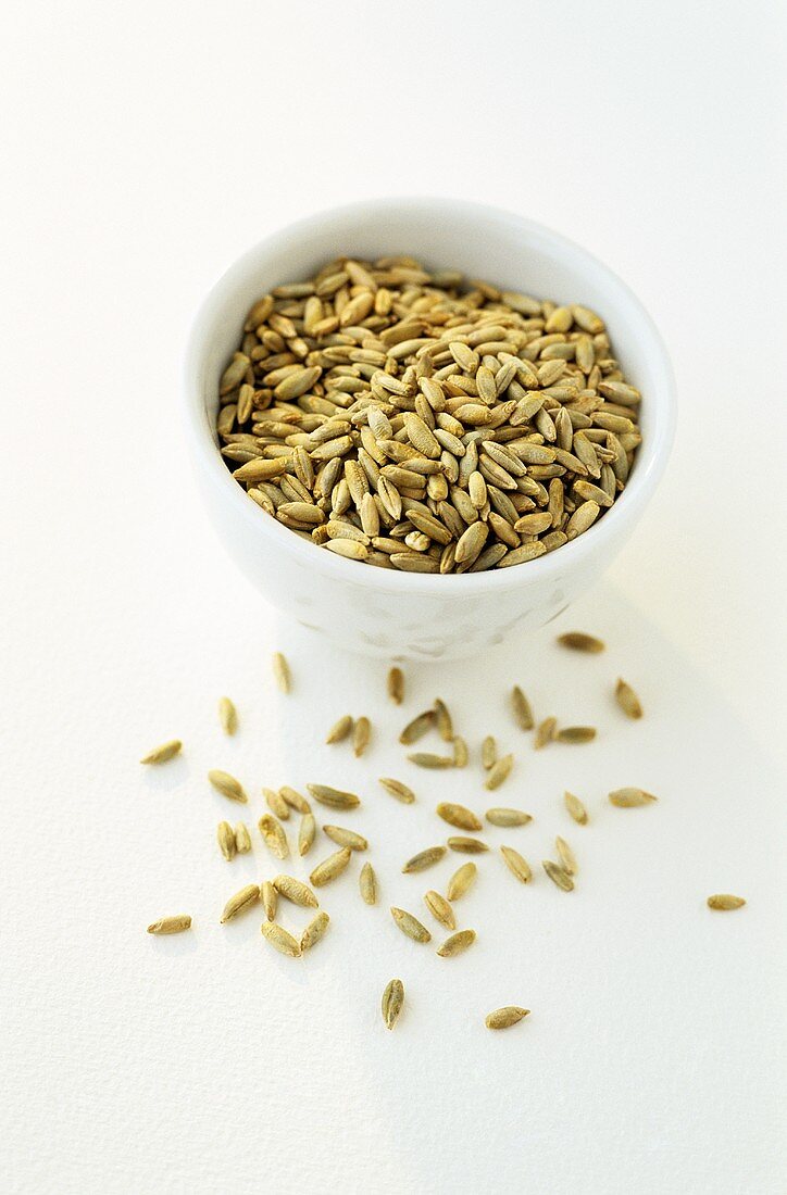 Wheat in and in front of a small bowl