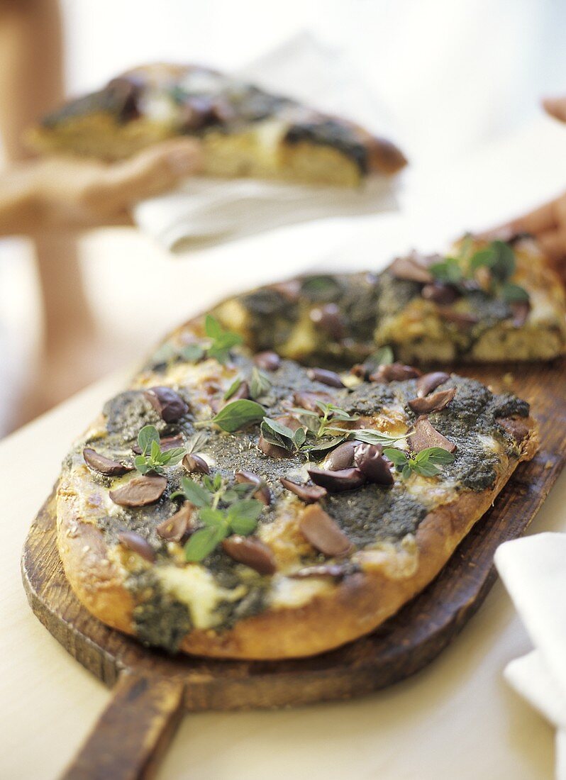 Toasted flatbread with pesto, cheese and olives