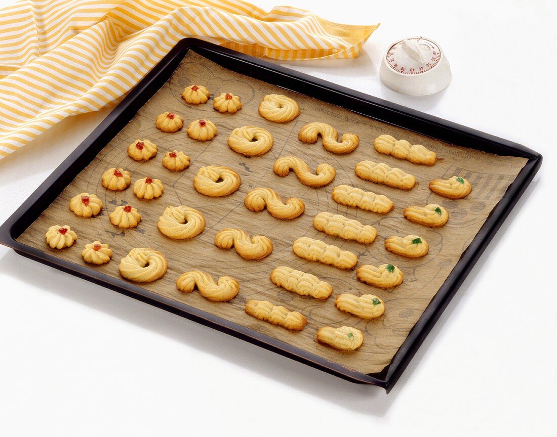 Assorted piped biscuits on a baking tray