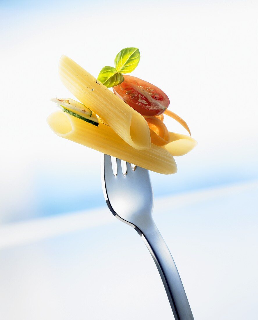 Penne with vegetables on a fork
