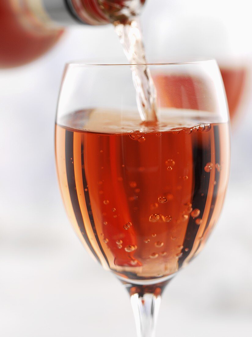 Pouring rosé wine into wine glass
