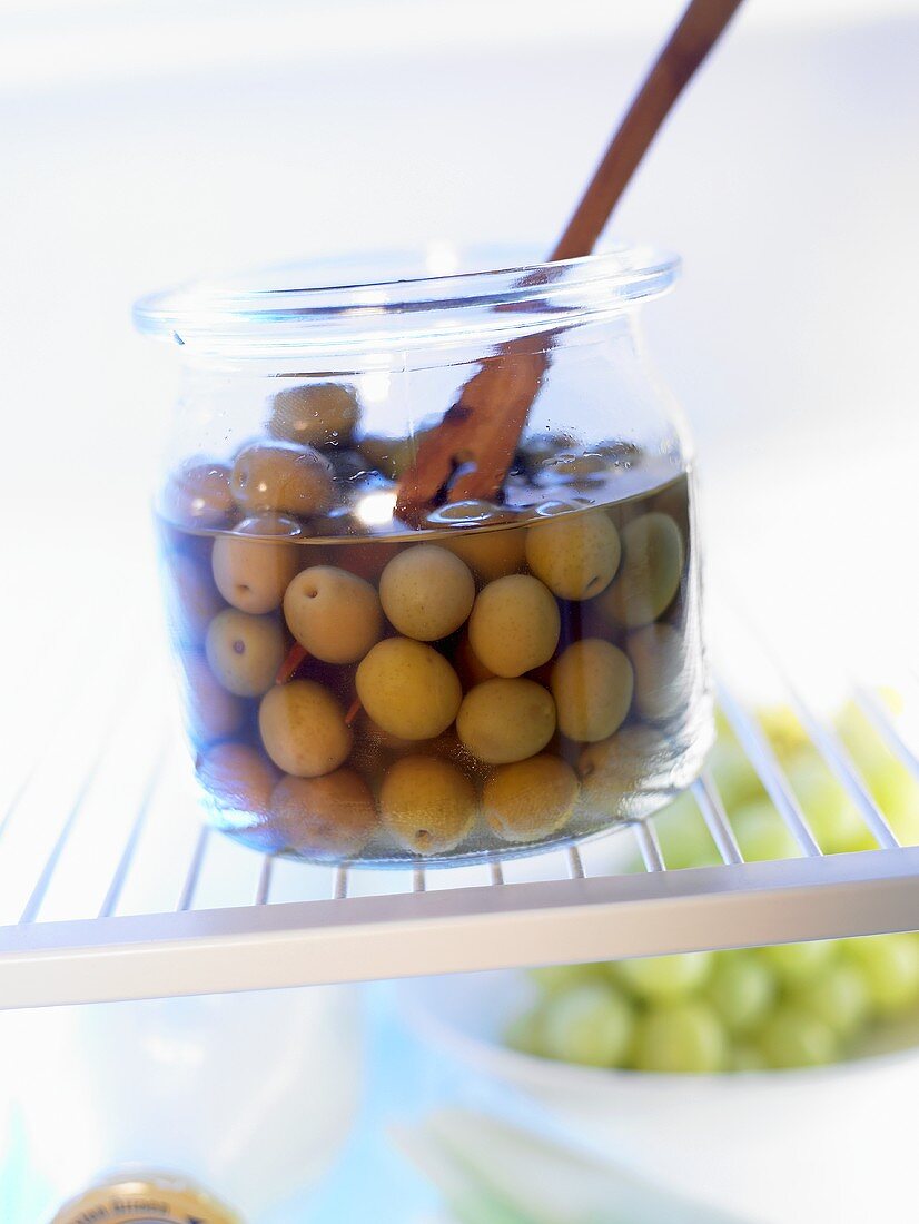 Grüne Oliven in einem Vorratsglas im Kühlschrank