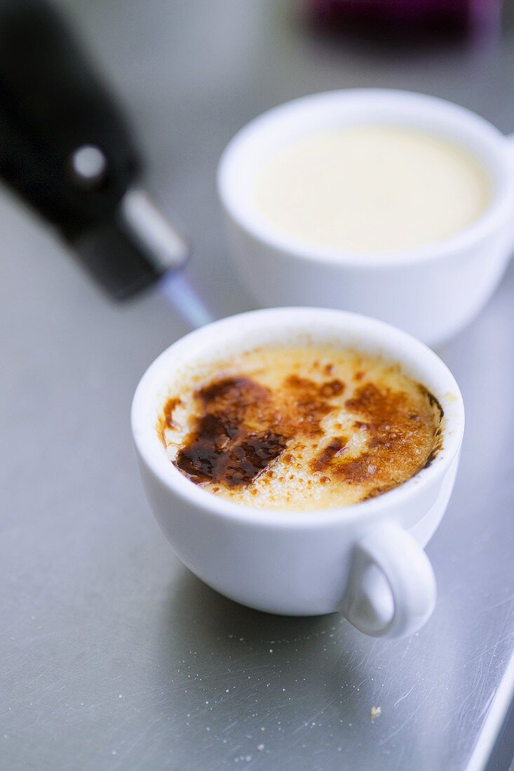 Crème brûlée being caramelised with Bunsen burner