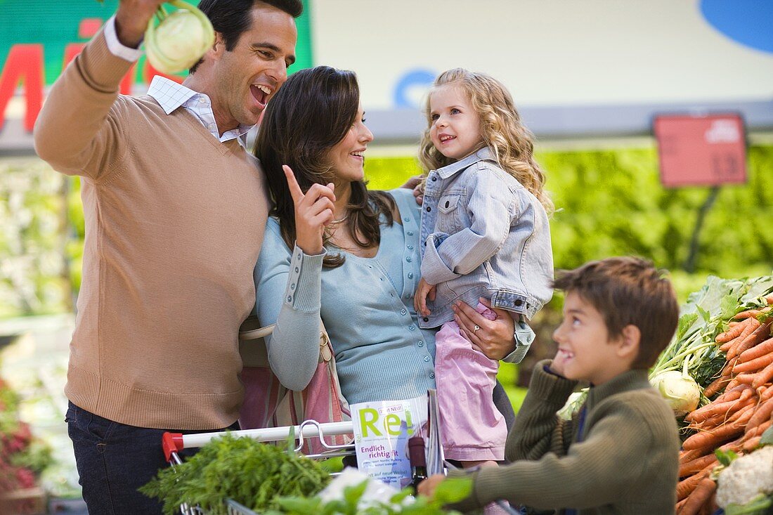 Familie bestaunt Kohlrabi im Supermarkt