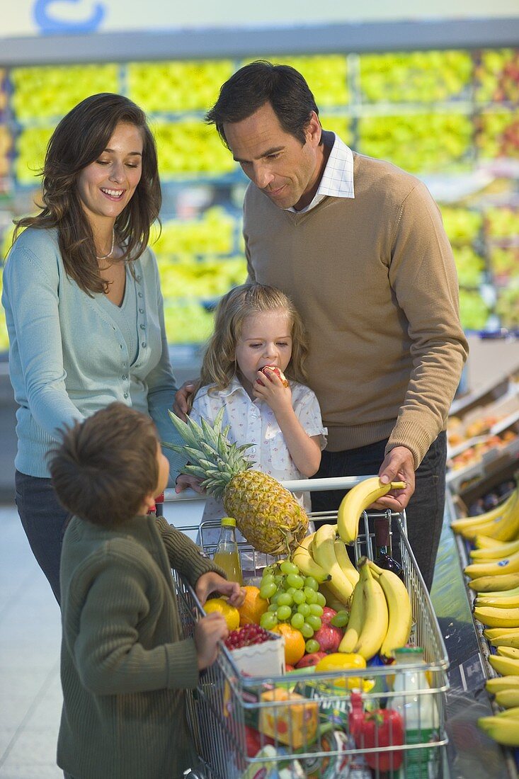 Familie am Obststand im Supermarkt