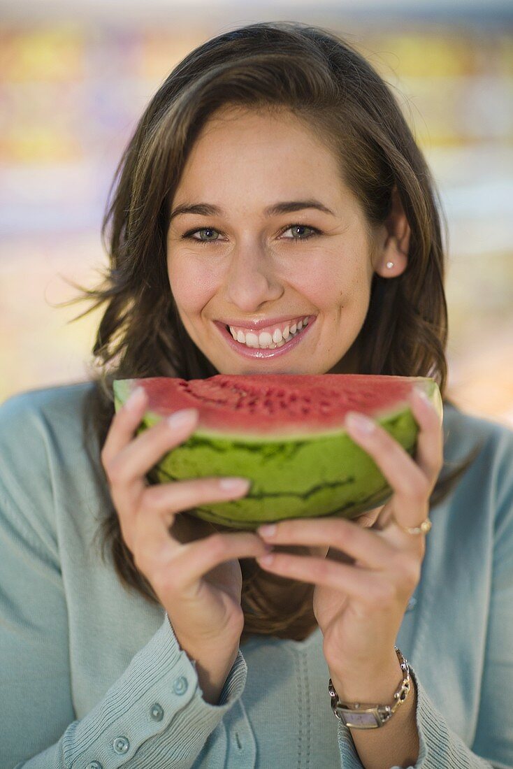 Junge Frau hält Wassermelonenschnitz in der Hand