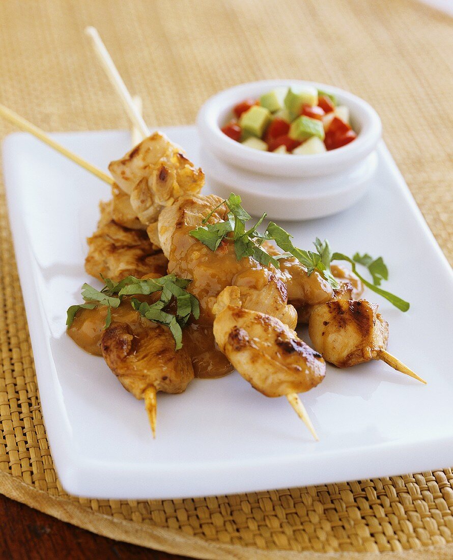 Chicken kebabs with peanut sauce and avocado salad