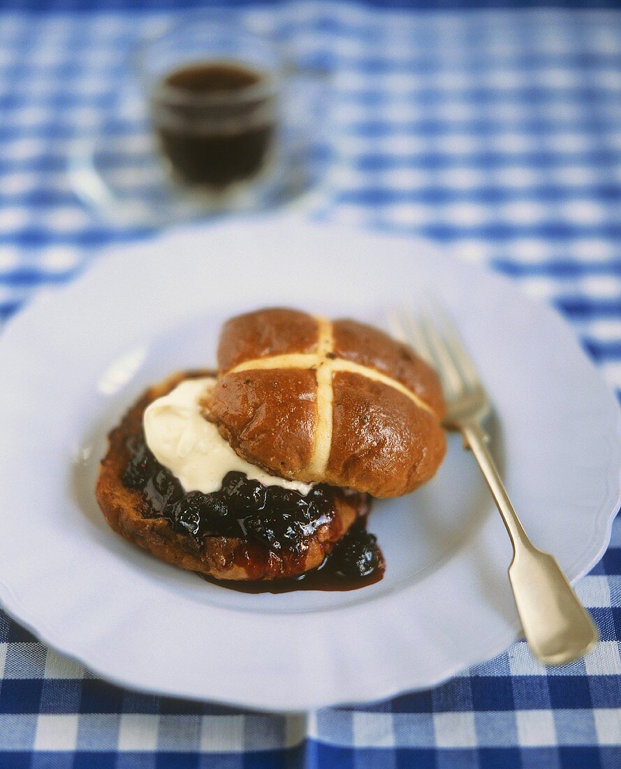 Hot cross bun with blueberries and cream