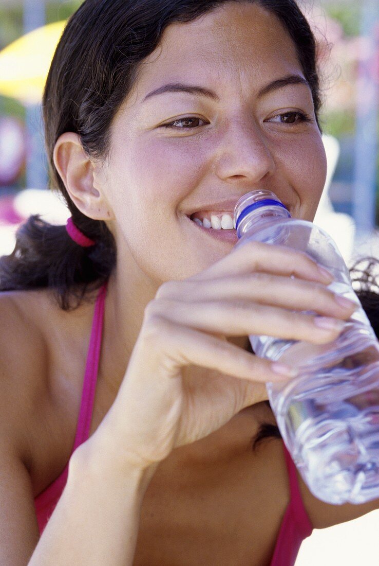 Junge Fraus trinkt aus Wasserflasche