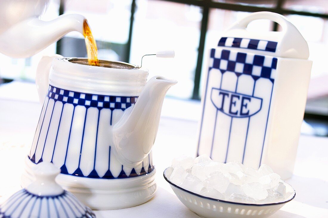 Tea being poured into a teapot