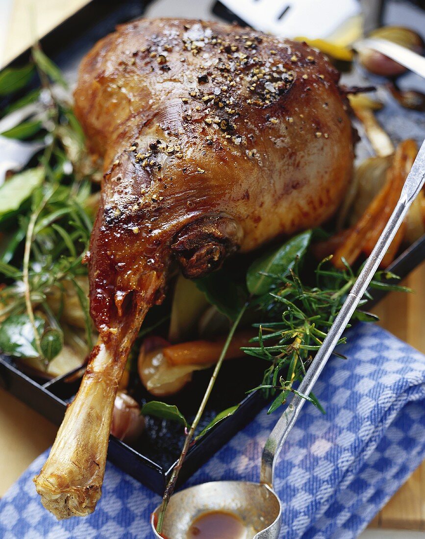 Braised leg of lamb with rosemary on baking tray