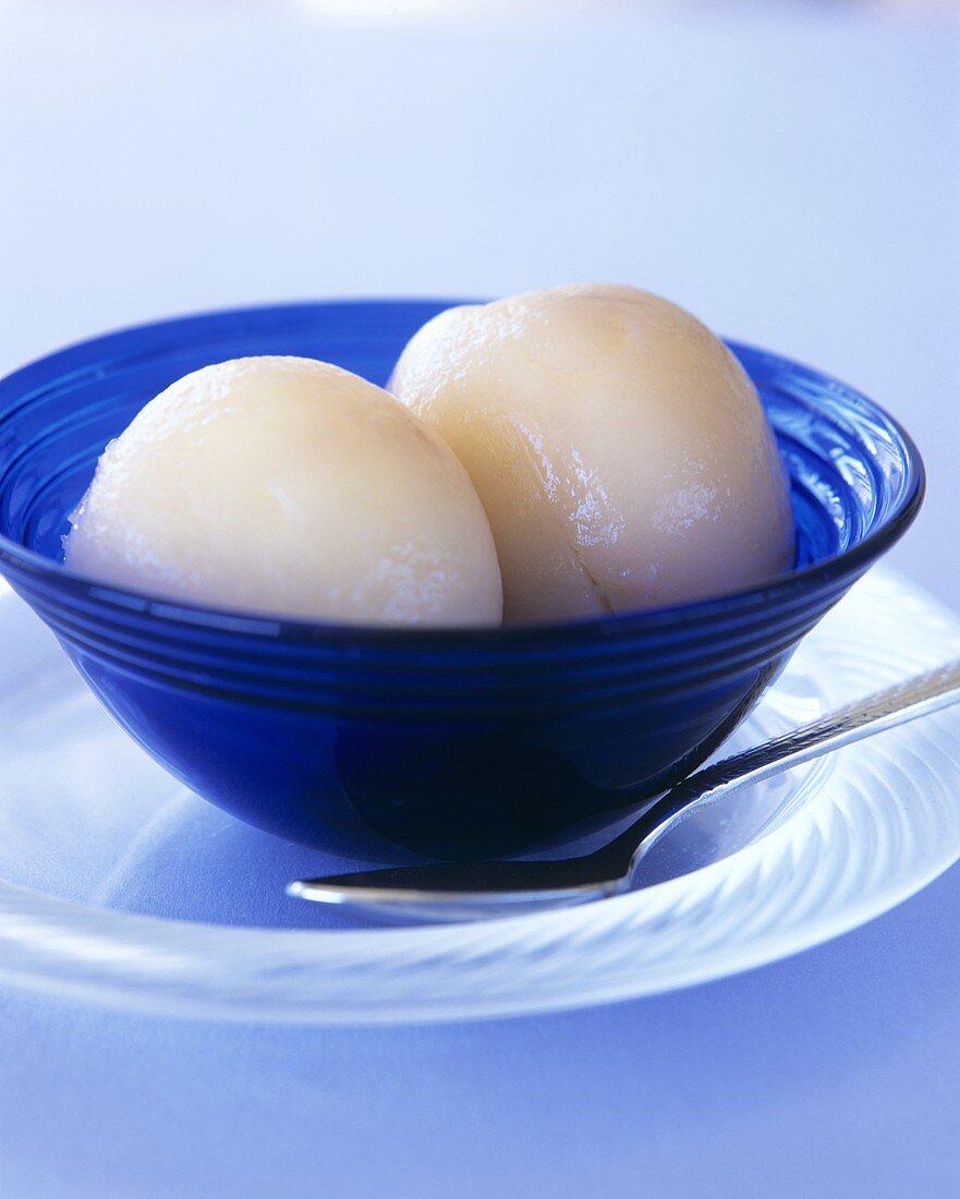 Bottled nectarines with honey in a blue glass bowl