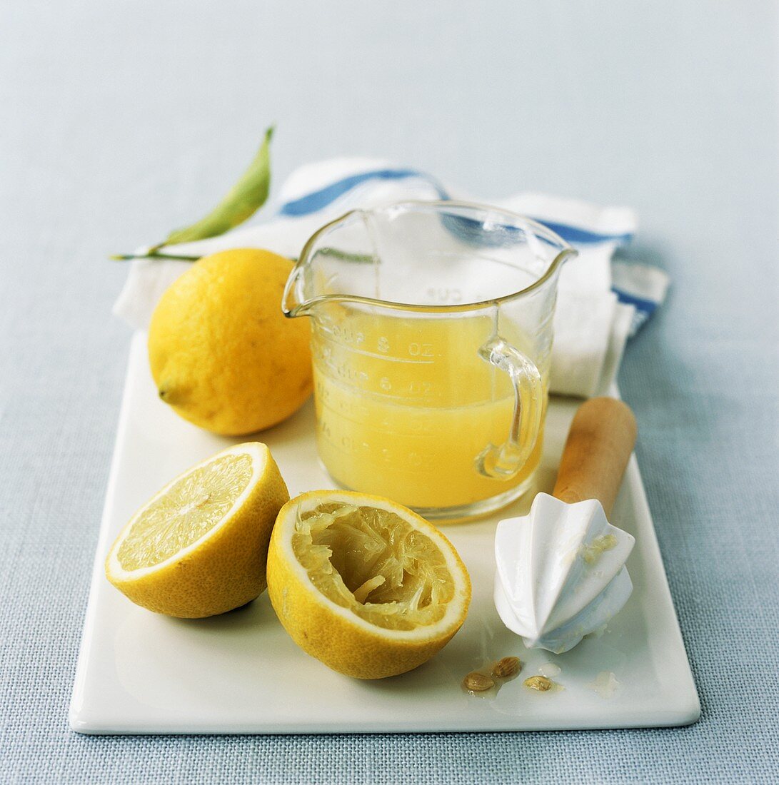 Lemons, lemon squeezer and lemon juice