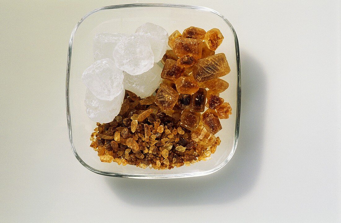 White and brown sugar crystals in a small bowl