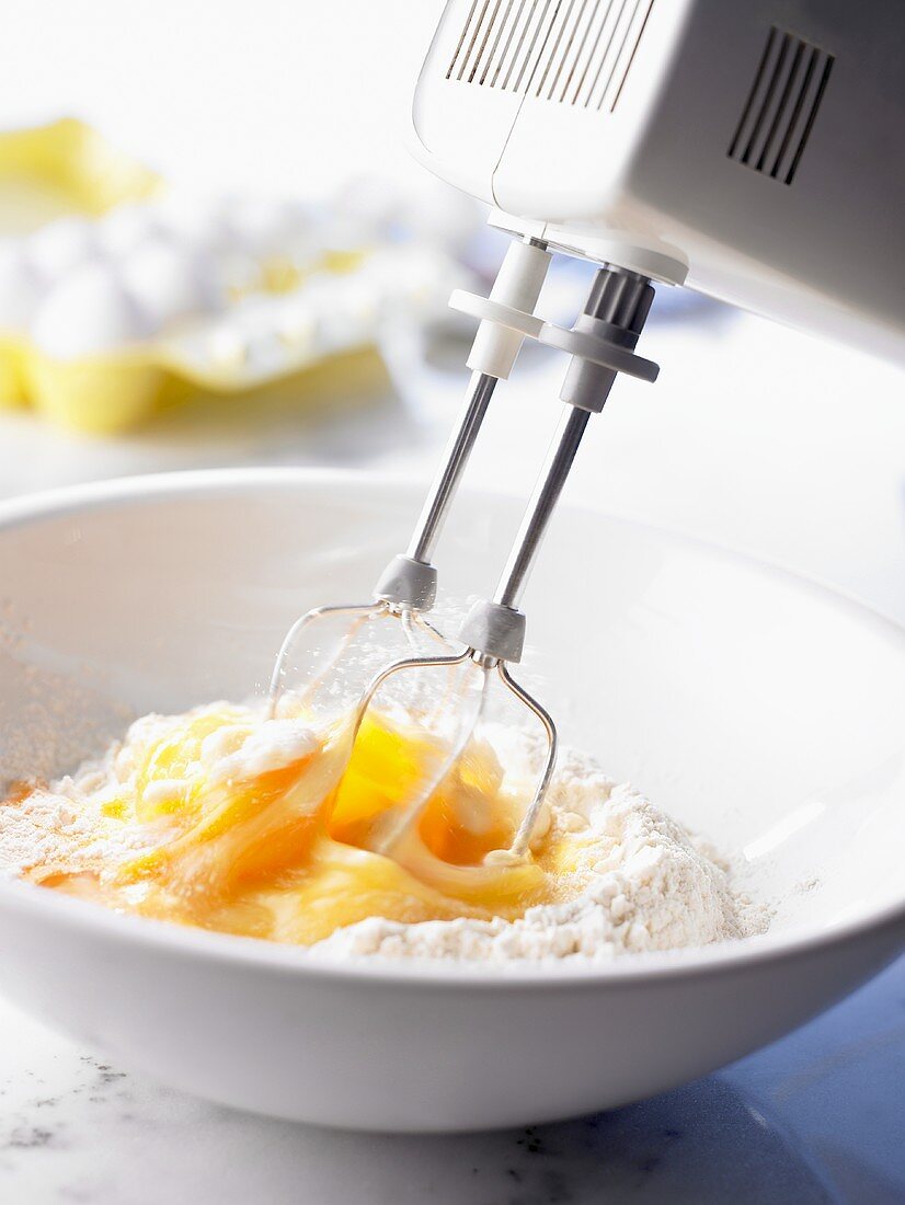 Mixing eggs into flour