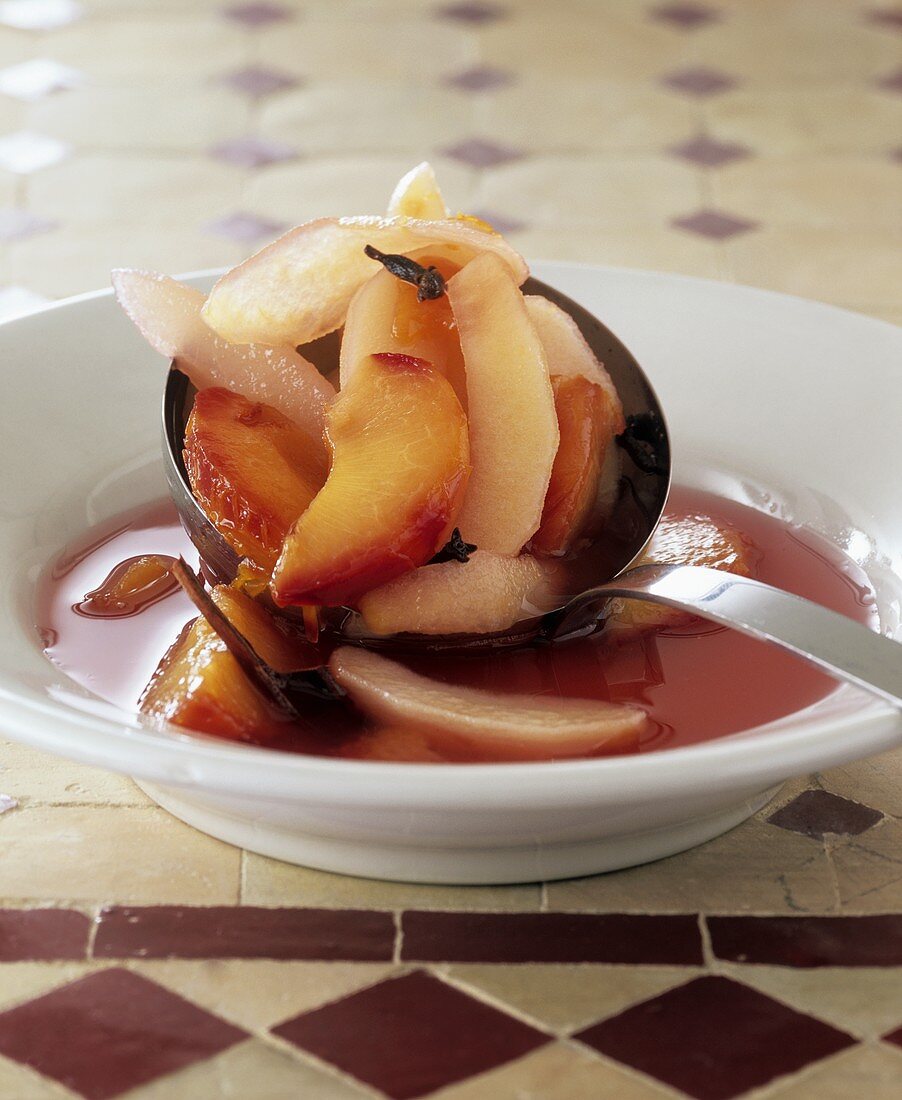 Apple, pear and plum compote with ladle
