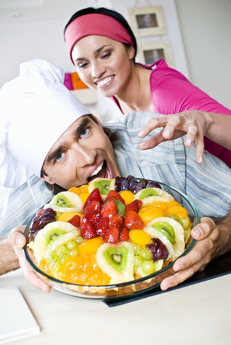 Mann und Frau heisshungrig vor einer Obsttorte