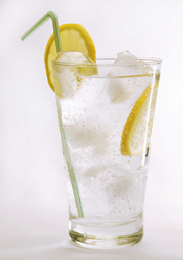 Glass of water with ice cubes, lemon and straw