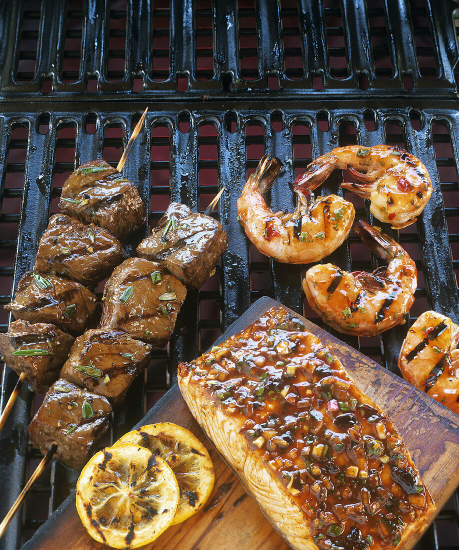 Salmon, beef kebabs and prawns on barbecue