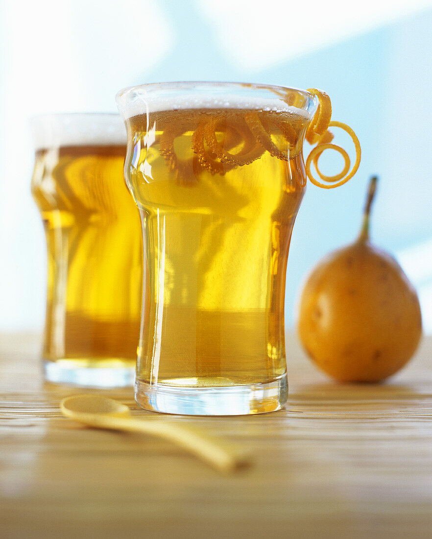 Zwei Gläser Fruchtlimonade, garniert mit Orangenzesten