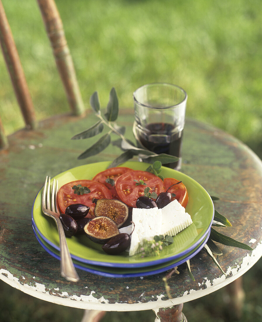 Greek appetiser plate: tomatoes, olives, figs & feta cheese