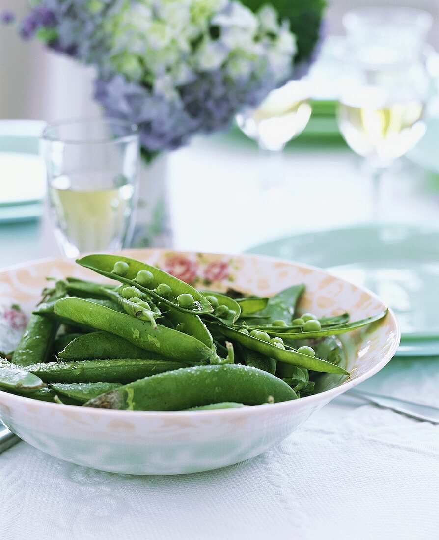 Pea pods in a dish on laid table