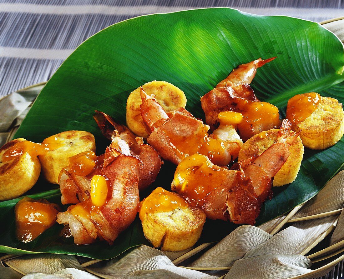 Bacon-wrapped shrimps with banana in banana leaf