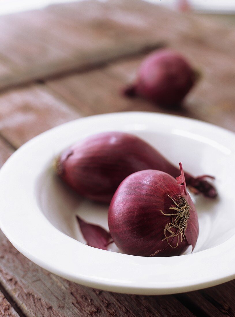 Two red onions in dish