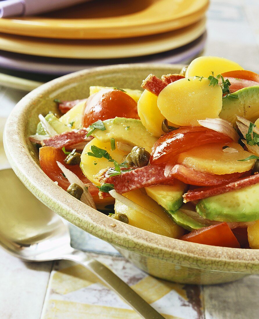 Potato salad with tomatoes, avocado and salami