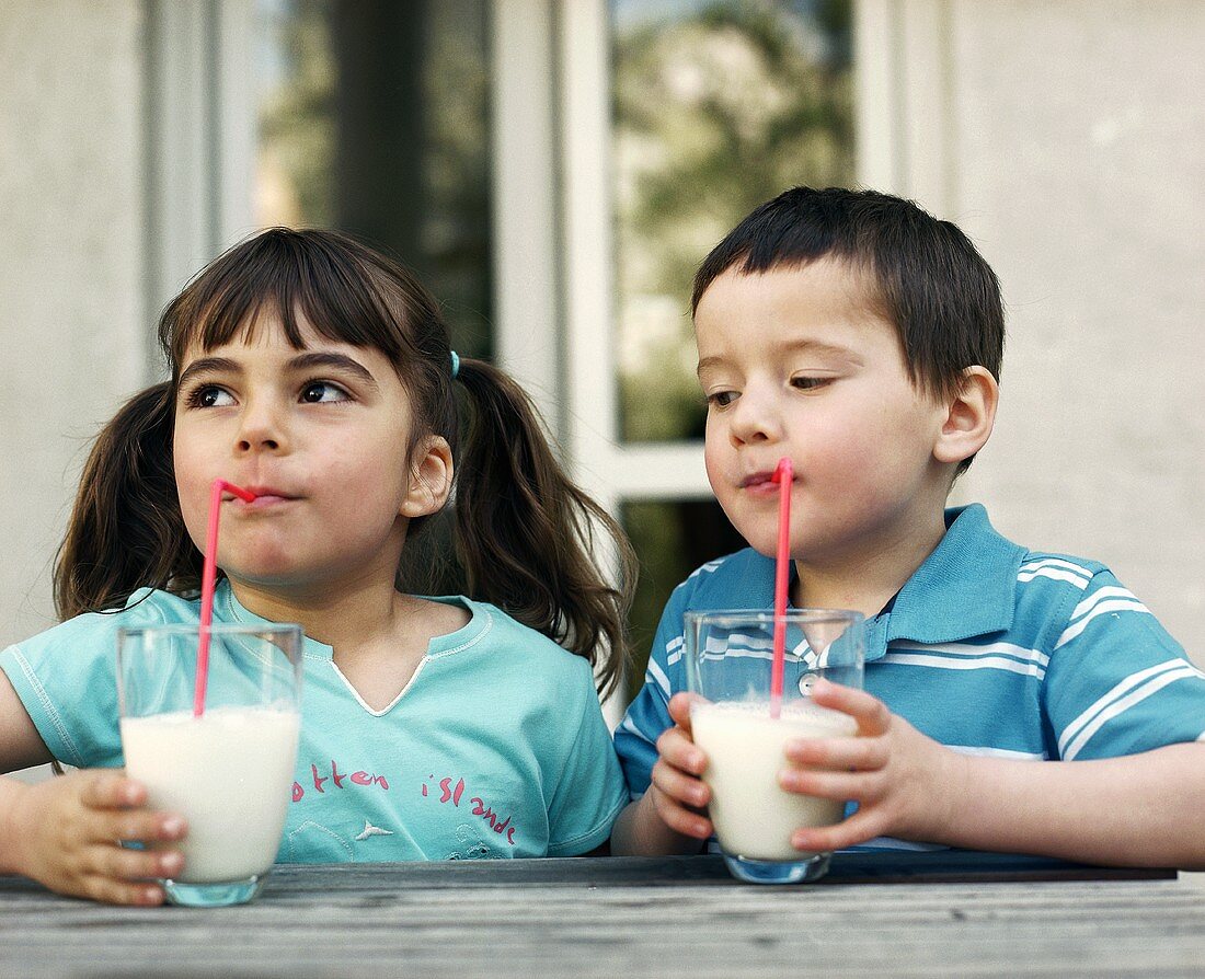 Two children drinking milk