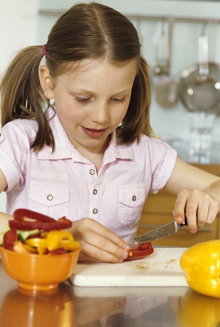 Girl cutting fresh pepper sticks