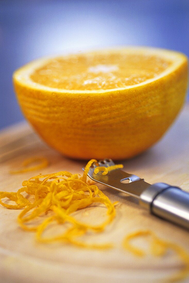Half an orange with zest and zester