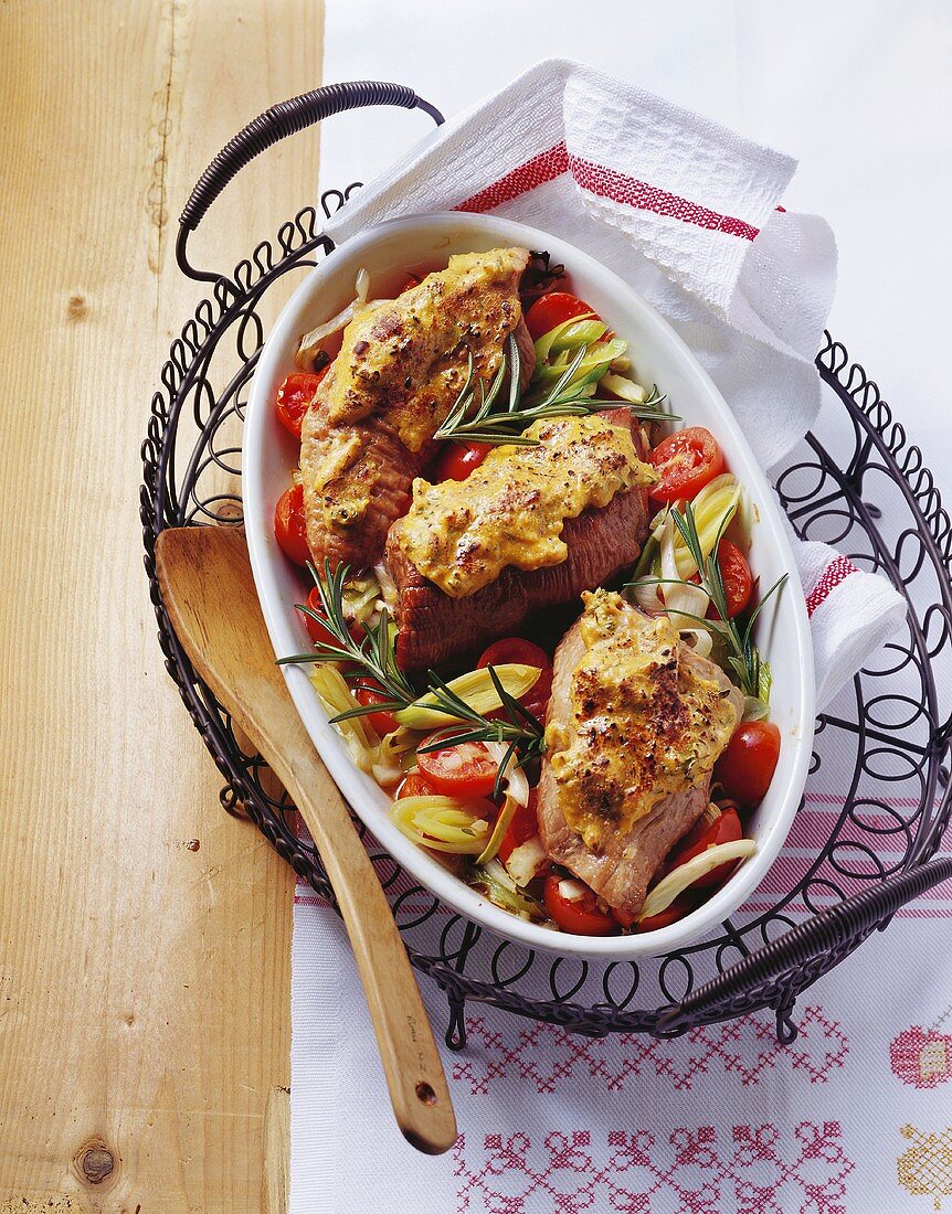 Braised pork fillet with mustard crust on vegetables