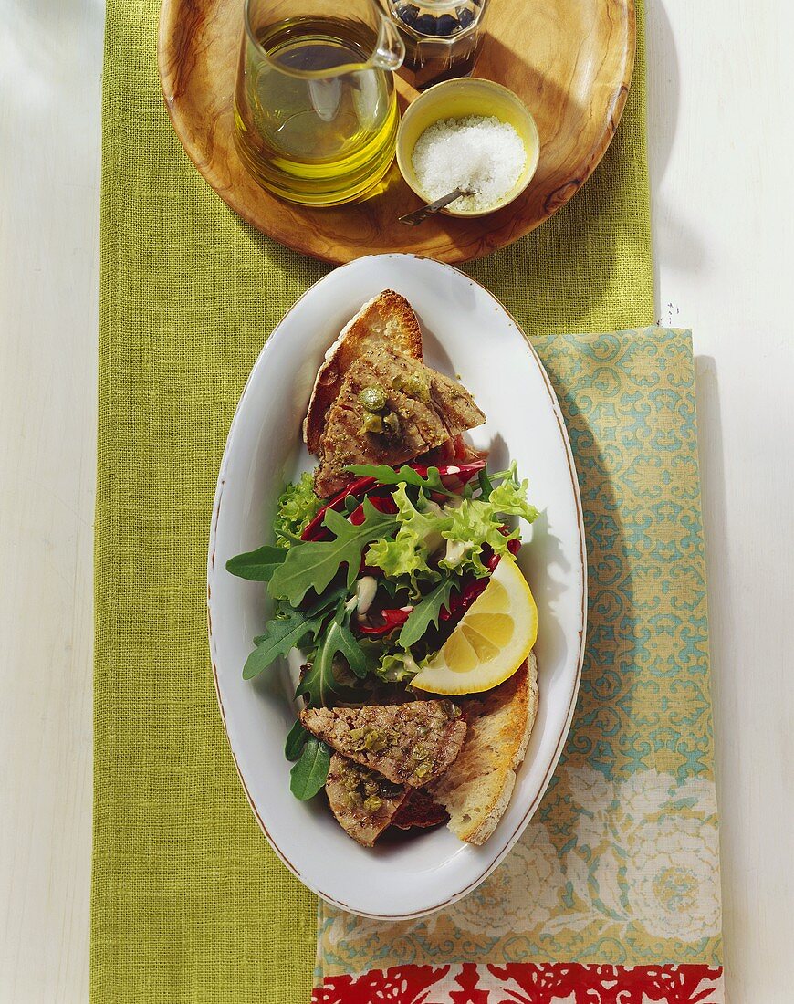 Grilled tuna with capers, bread and salad