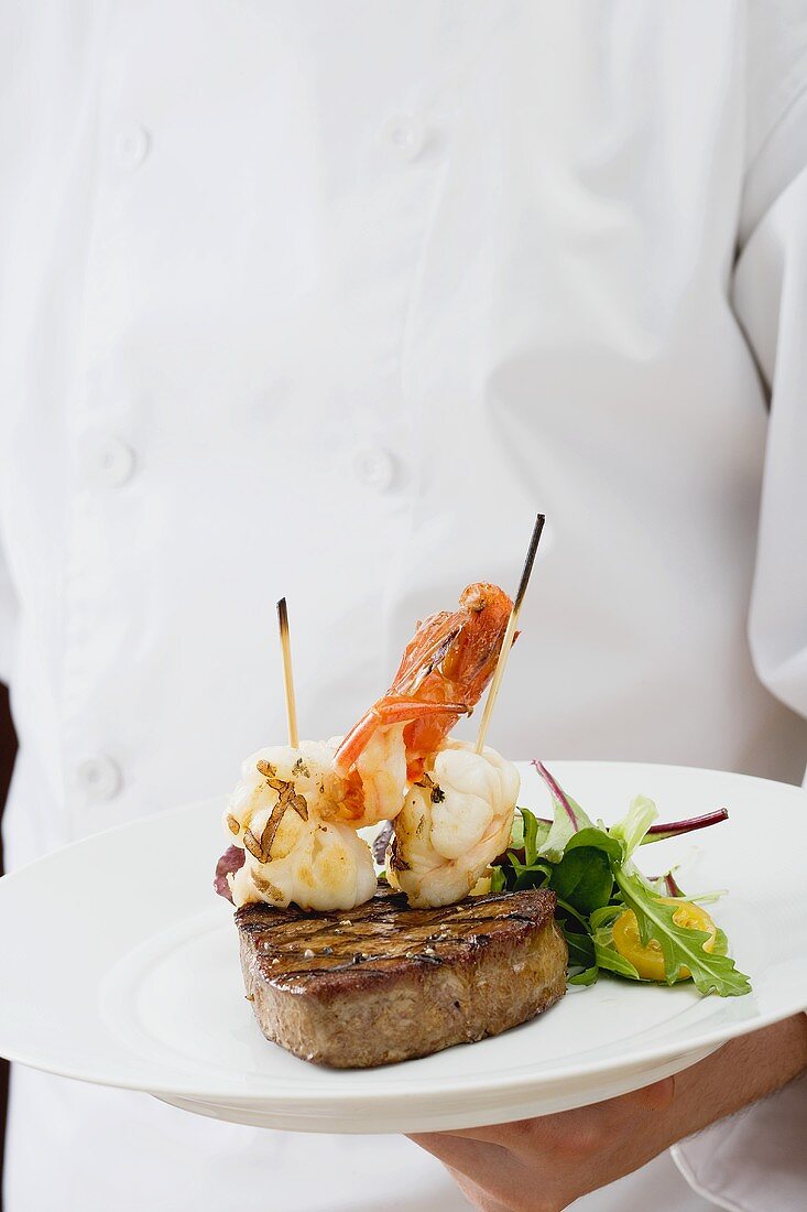 Waiter serving Surf and Turf on a plate
