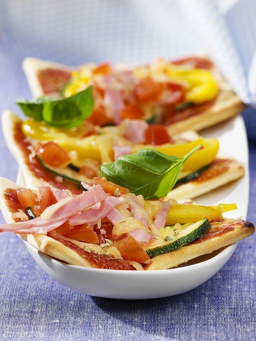 Three pizza slices with ham and vegetable topping