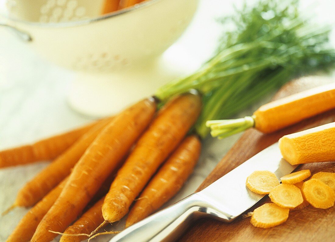 Carrots and carrot slices on wooden board